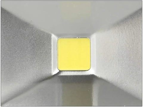 Close-up view of LED chip in aluminum housing for 100W floodlight, featuring a yellow light source for outdoor waterproof use.