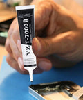 Person using Ultra Strong T7000 Phone Repair Glue For Screen And Frame Repair Multipurpose Adhesive For Cell Phones Back Covers And LCD Cracks Sticks Like Crazy For Durable Repairs Without The Hassle.