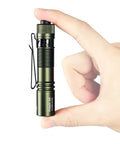 Person holding Pokelit AA Rechargeable Mini EDC Flashlight With Clip 550 Lumens High CRI 90 LED for everyday use, dark green