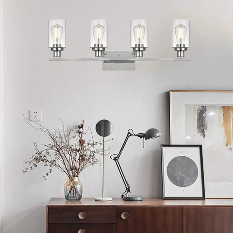 Brushed Brass 4-Light Vanity Sconce With Clear Glass Cylindrical Shades displayed above a modern desk setting.