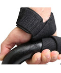Close-up of hand holding barbell with black one pair lightweight weightlifting straps with cotton pads for barbell training.