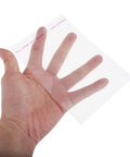Hand holding 100 Pcs Resealable OPP Cellophane Bags For Cookies And Snacks, showcasing clear, self-sealing packaging bag.