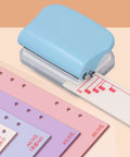 Three Hole Paper Punch Handheld DIY Binder Tool With Metal Base And Plastic Cover, punches up to five sheets, B5 size visible.