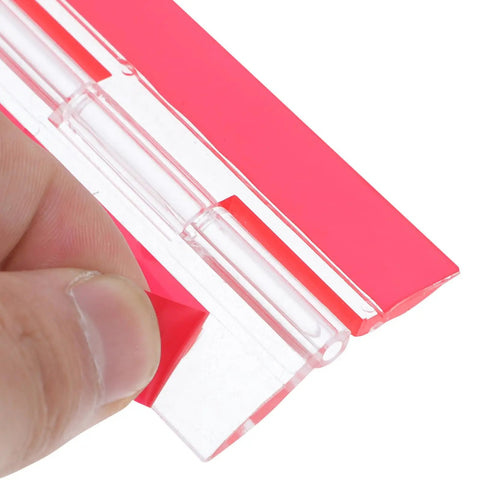 Close-up of clear self-adhesive acrylic hinges 100x42mm with red backing, showing installation for cabinets and wooden boxes.