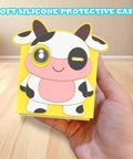 Sweet Soft Silicone Case for Nex Playground Game System with cow print design being held in hand on wooden surface.