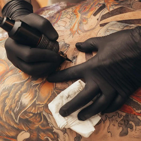 Tattoo artist wearing Heavy Duty Black Nitrile Gloves 7 Mil 100 Pack Large L Full Palm Textured Ambidextrous Latex Free