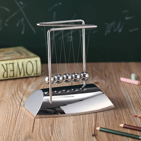 Z Shape Newton's Cradle Pendulum Balls For Learning And Home Office Decoration on wooden desk with chalk