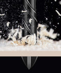 Front view of a 5mm masonry drill bit with tungsten carbide tip drilling into a surface; dust and chips flying
