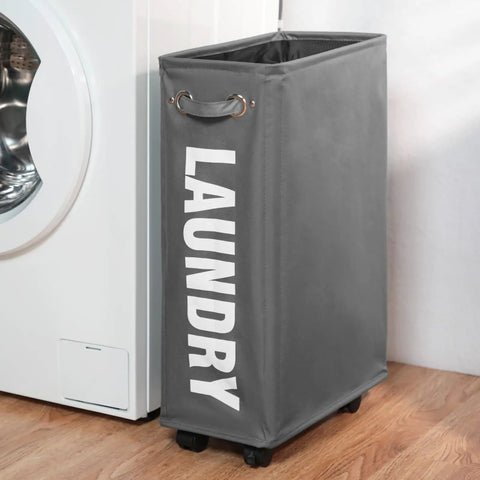Slim Laundry Basket On Wheels With Grab-and-Go Handle, Collapsible Rolling Hamper, Gray, next to washing machine.