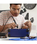 Young man using Top Tier Cordless Pen Engraver And Digital Soldering Iron Kit With Sweet 20V Battery and Solid 46 Piece Wood Burner for DIY.