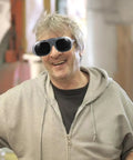 Happy man wearing Heavy Hitter Welding Goggles With Black And Gray Tinted Lenses, ideal for industrial safety tasks.