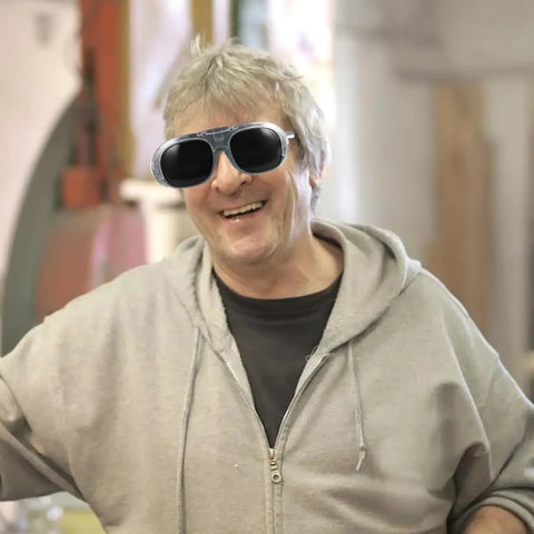 Happy man wearing Heavy Hitter Welding Goggles With Black And Gray Tinted Lenses, ideal for industrial safety tasks.