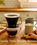 Pour Over Coffee Filter Cone, Number 1 Size, Black, BPA Free Polypropylene, brews coffee over a mug, with cookies beside.