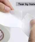 Hands tearing Heavy Duty White Duct Tape 2 Inch By 30 Yards 3 Pack 8.27 Mil All Weather Tear By Hand No Residue product.