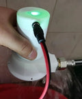Person holding Portable 50W Micro Hydro Generator With Brushless Water Turbine in hand, connected with pipe adapter for off-grid power.