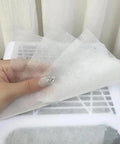 Hand holding 100 Pack Disposable Nonwoven Filter Cloths for Nail Vacuum Cleaners Nail Art Dust Collector Replacements