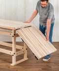 Person assembling Folding Top Extension Kit for Workbench, space saving expansion that adds a large, stable work surface.