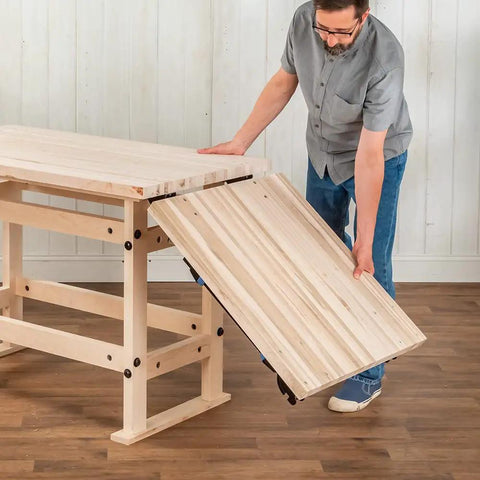 Person assembling Folding Top Extension Kit for Workbench, space saving expansion that adds a large, stable work surface.