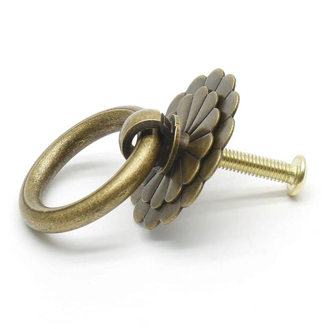 Close-up of four piece bronze antique brass ring pull handles set with screws flower pattern vintage style cabinet knobs