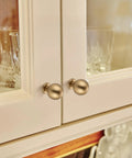 Super Durable Zinc Alloy Round Ball Cabinet Knobs One Inch Diameter Twelve Pack Champagne Bronze handles on kitchen cabinet doors.