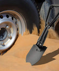 Grab And Go Folding Shovel For Car And Camping 18.5 Inch Collapsible Shovel With Pickaxe in sand near car wheel