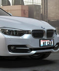 White car with Sick Carbon Fiber License Plate Frame 2 Pack With Fasteners And Screws, glossy plastic mount, modern design.
