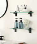 Two Pack 16 Inch Tempered Glass Bathroom Shelves With Matte Black Wall Mount Floating Shelves For Vanity Or Shower Sturdy Modern Storage Easy Install Space Saving Design For Quick Organization showcasing toiletries on bathroom wall.