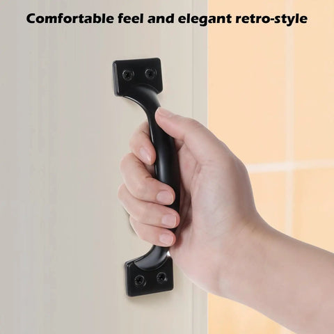 Hand grasping black iron handle from Six-Piece 5 Inch Rustic Gate Handle Set - Built Tough Heavy-Duty Iron Door Pulls With Screws For Barn Doors.