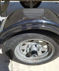Stainless Steel Bearing Protector for 2.047 Inch Inside Diameter Hubs installed on utility trailer wheel, heavy-duty and saltwater ready.