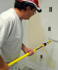 Person using Pro Extension Pole 3 To 6 Ft With Twist-Lok Locking for painting with fluted fiberglass handle and anodized aluminum slider