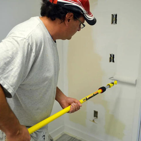 Person using Pro Extension Pole 3 To 6 Ft With Twist-Lok Locking for painting with fluted fiberglass handle and anodized aluminum slider