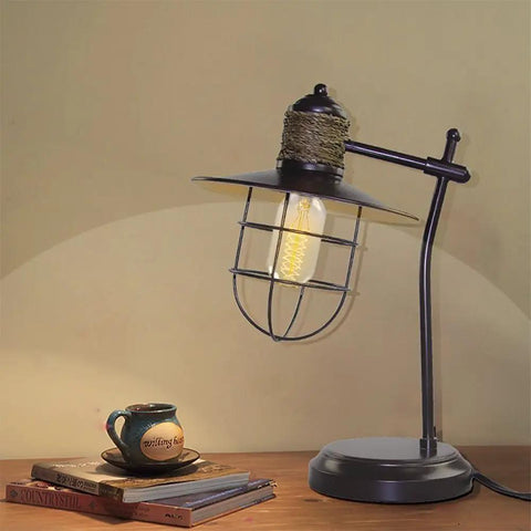 Old School Retro Edison Style T45 25W light bulb in cage lamp on table, vintage decor.