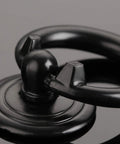 Close-up of one black vintage ring drawer pull from Four Pack Vintage Ring Drawer Pulls For Dresser Cupboard Doors, Old School Retro Vibe Cabinet Knobs In Black, Durable Zinc Alloy Hardware 1.77 By 1.34 Inches For Wardrobe, Chest, Bin, And Other Furniture.