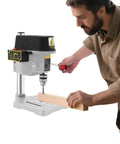 Portable Desktop Drill Press For Wood And Metal, 340W Electric Mini Bench Drill in use with a wood piece.