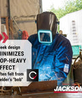 Welder wearing HLX 100 Welding Hood Lightweight Fixed Front Helmet Shade 10 ANSI Z87.1 Hydraflex Shell, sparks flying in workshop.
