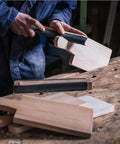 Person using Auto Body Sanding Kit With 28 Pcs Wet Dry Sandpaper Pack on wooden boards, showing sanding process.