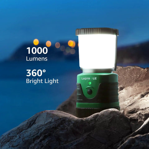 Bright 1000 Lumen Rechargeable Go To Camping Lantern With 4400mAh Power Bank Green LED Tent Light on rocks at dusk