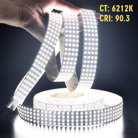 Hands holding Quad Row 24V DC LED Strip Light Daylight White 90 CRI Flexible Tape 5m 16.4ft 17,650 Lumens, emitting bright light