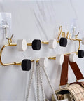 Top Tier Wrought Iron Letter Wall Hooks Slick Gold Finish Heavy Duty Coat And Key Hangers Modern Entryway Decor displayed with hooks and bags.
