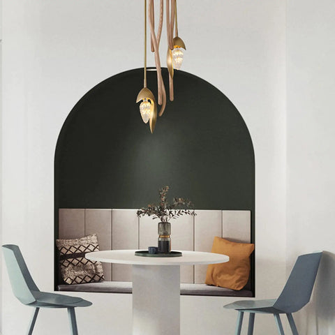 Sleek Three Light Solid Wood Pendant Lamp With Energy Saving Led Fixtures hanging over a round table in a modern dining nook.