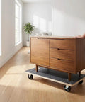 Heavy Duty Wooden Moving Dolly Set With 4 Smooth PP Wheels And Smart Brakes transporting a wooden cabinet on hardwood floor in bright room.