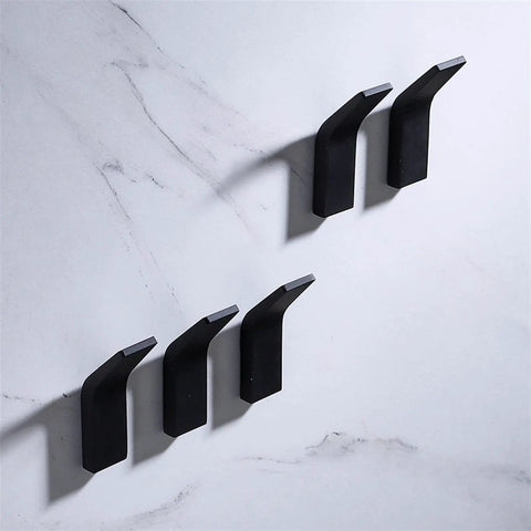 Pretty Slick No Drill Wall Mounted Robe Hooks For Bathroom Towels And Coats, sleek black aluminum hooks mounted on marble.