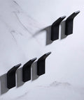 No Mess Punch Free Wall Mounted Robe Hooks Top Shelf Aluminum Towel Rack sleek black hooks mounted on marble wall.