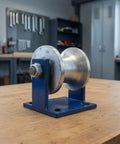 Smooth Operator V Shaped Gate Track Roller With Rock Solid 130X130mm Mounting Base on a workbench, steel wheel design.
