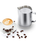 32oz Milk Frothing Pitcher With Latte Art Pen For Espresso Machines And Coffee Bar Stainless Steel Milk Jug next to latte art coffee cup