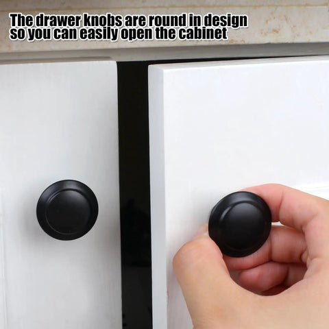 Hand holding knob from Set Of 18 Black 30mm Cabinet Knobs And Drawer Pulls With Screws For Dressers And Kitchens Durable Matte Finish Easy Install
