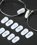 Hella Soft Anti Slip Silicone Eyeglass Nose Pads 18 Pair Replacement Kit With Cleaning Cloth Super Snug Grip Featherlight Allergy Free For Glasses And Sunglasses Small White displayed on black background.