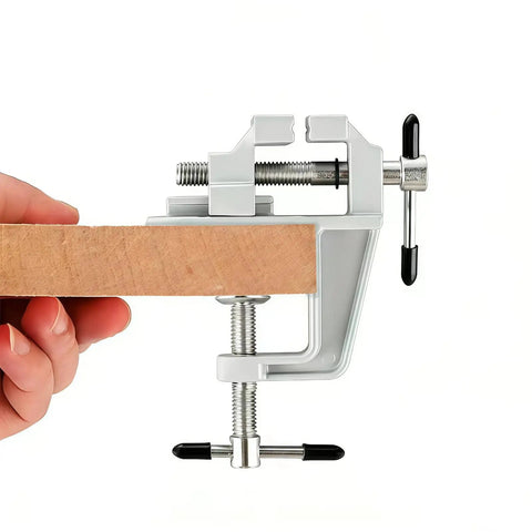 Heavy Duty Aluminum Bench Vise With Mini Clamp For DIY Jewelry Making And Electronics Repair clamping wood piece on white background