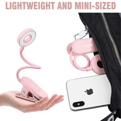 Stepless Dimming Clip On Book Light with 12 LEDs, magnetic clip and pink color, shown in a hand and beside a smartphone for size reference.