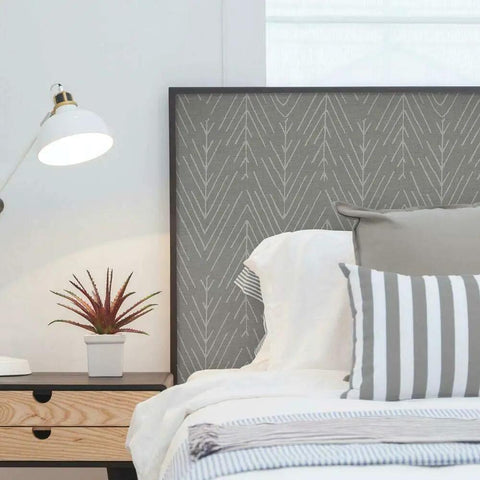 Charcoal Gray Twig Hygge Herringbone Peel And Stick Wallpaper applied on headboard in cozy bedroom.